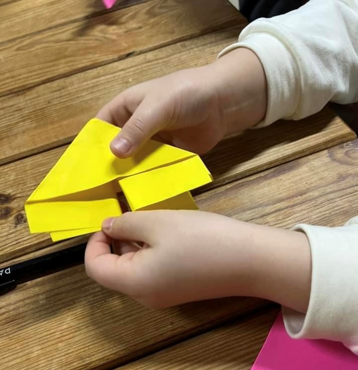 Mani di bimbo giocano con una barchetta di carta